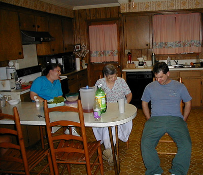 Monica, Aunt Lou, and Louis sitting in Aunt Lou's kitchen