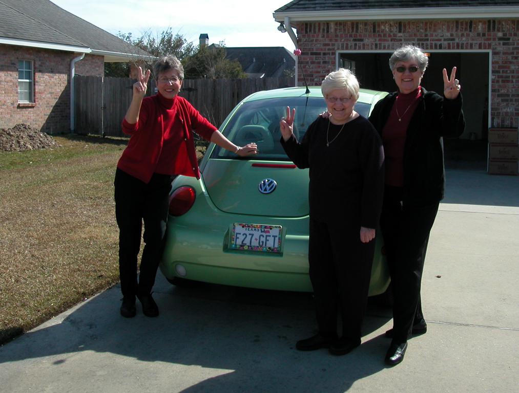 Aunt Beryl, Mom, and Dolores joking around in front of Aunt Beryl's lime green VW Beetle in Mom's driveway