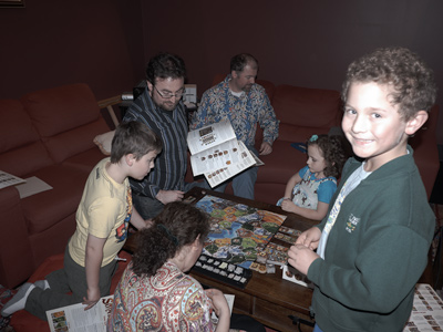 Jackie, James, Rick, Steve, Sophia, and John playing SMALL WORLD® in the living room