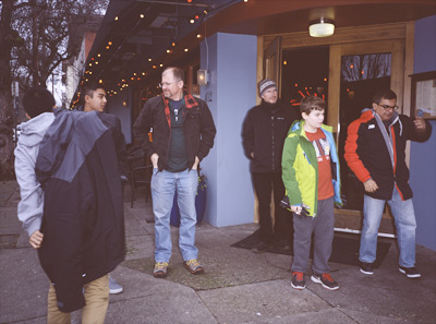 Mikhil putting on his jacket, Kieron talking to Steve, Marc, James, and Naresh, all standing outside BLUE MOON CAFE after lunch