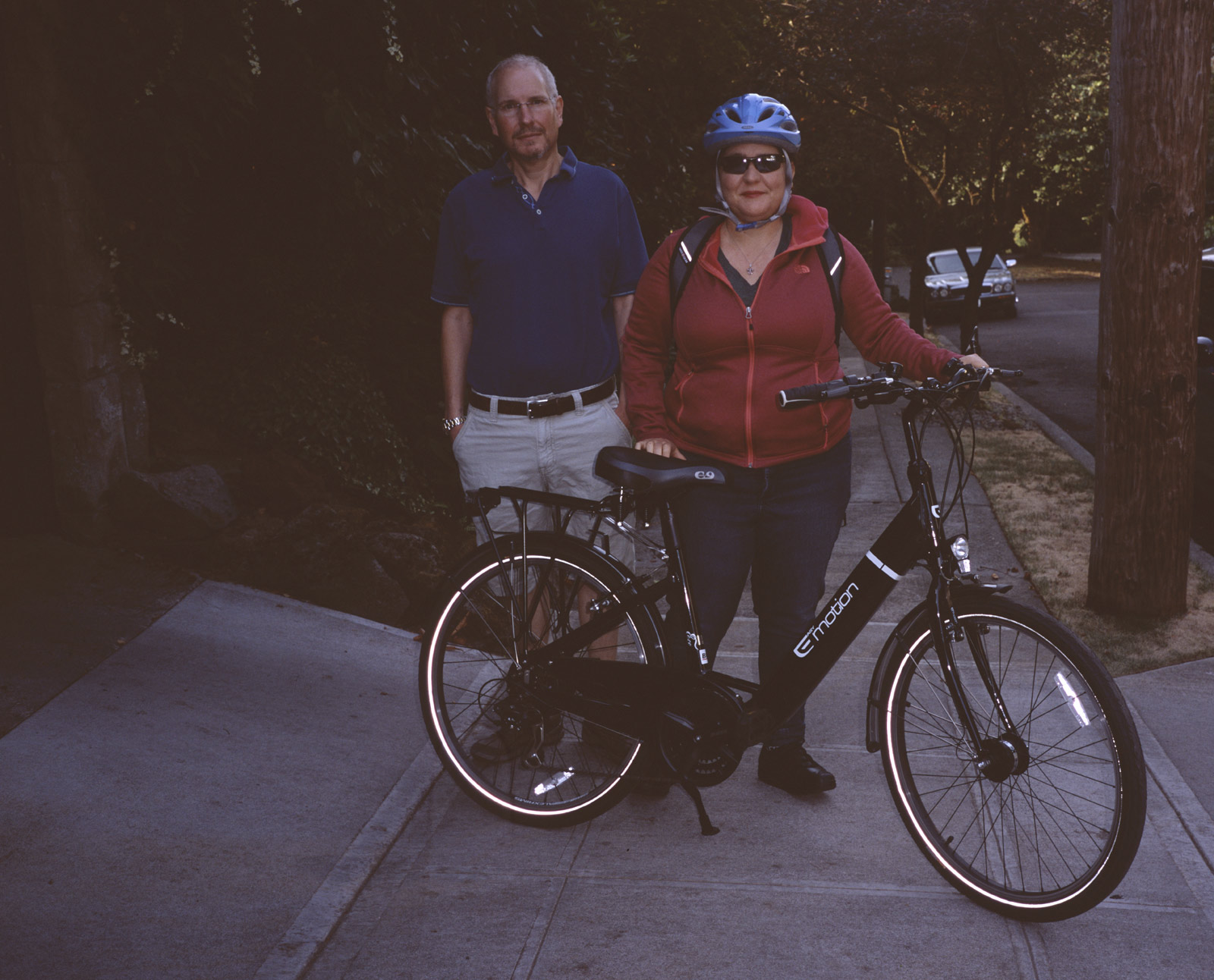 Marc and Jackie standing behind Jackie's motorized bicycle as Jackie is about to leave for work