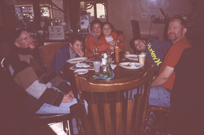Marc, John, Sophia sitting on Jackie's lap, James acting goofy, and Steve eating breakfast at JAVA LOVE CAFE SEDONA