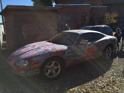 Sophia walking away from a totally cool tie dye painted sporty car parked at the former Jerome High School