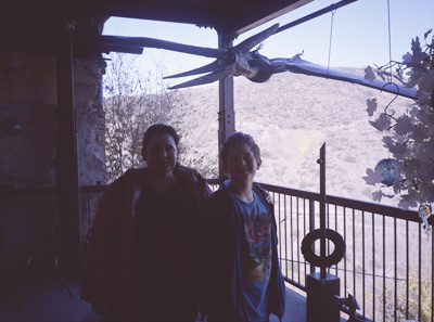 Jackie and John standing underneath a cool Pterodactyl model on NELLY BLY's back porch