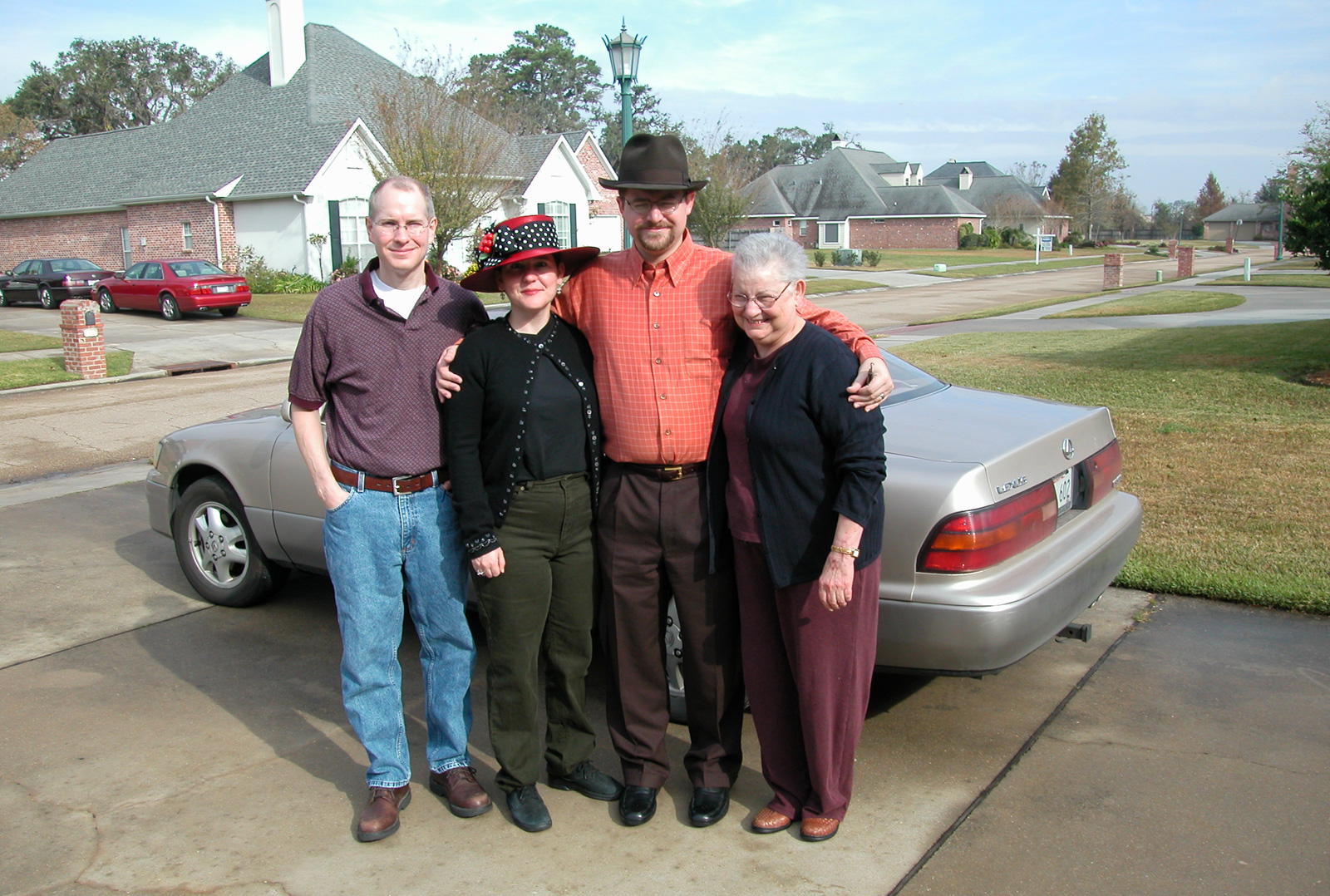 Marc, Jackie and Steve, and Mom in front of Marc's car, in Mom's driveway