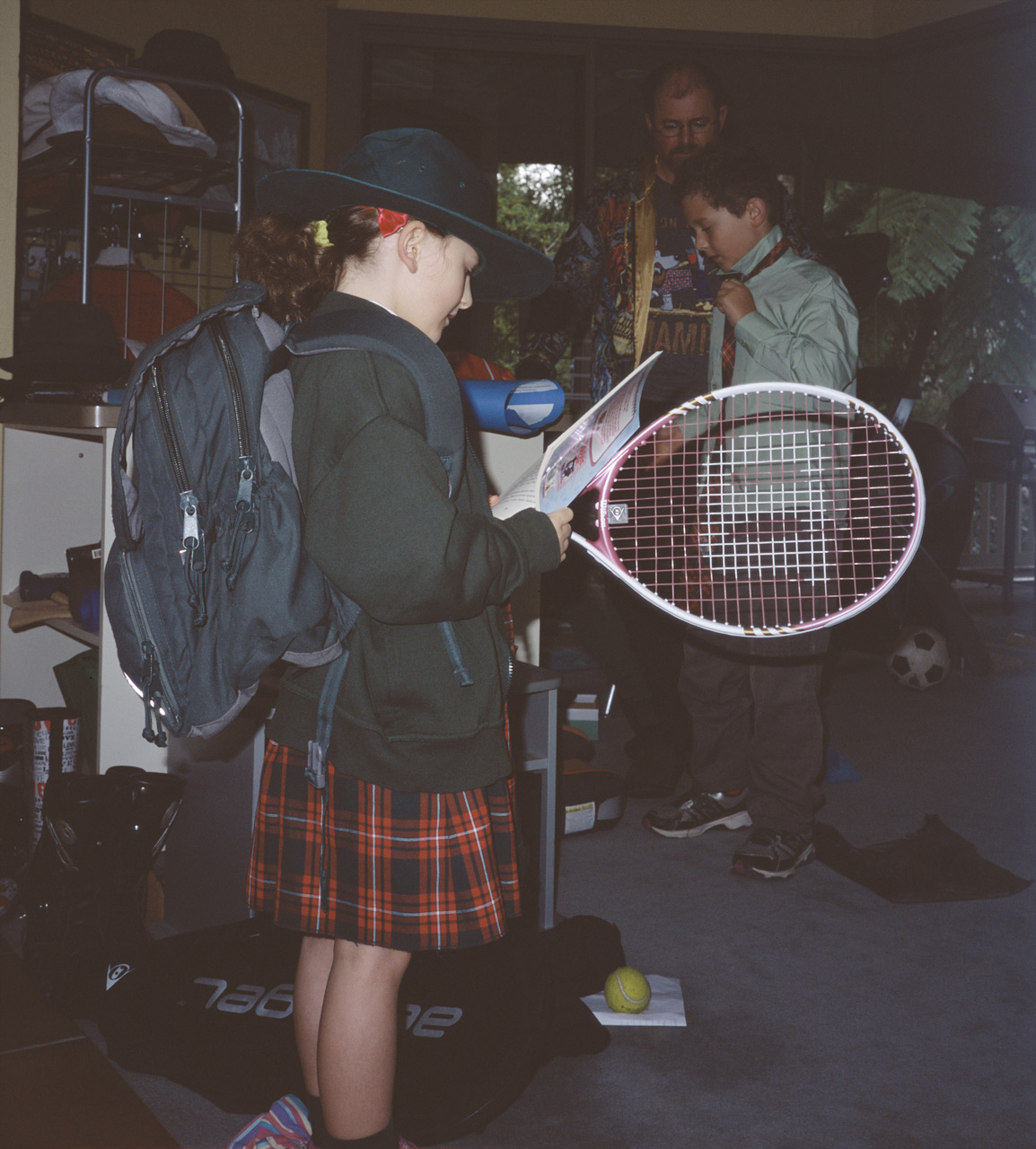 Sophia holding her tennis racket, John tying his tie, and Steve helping him in the play room before school